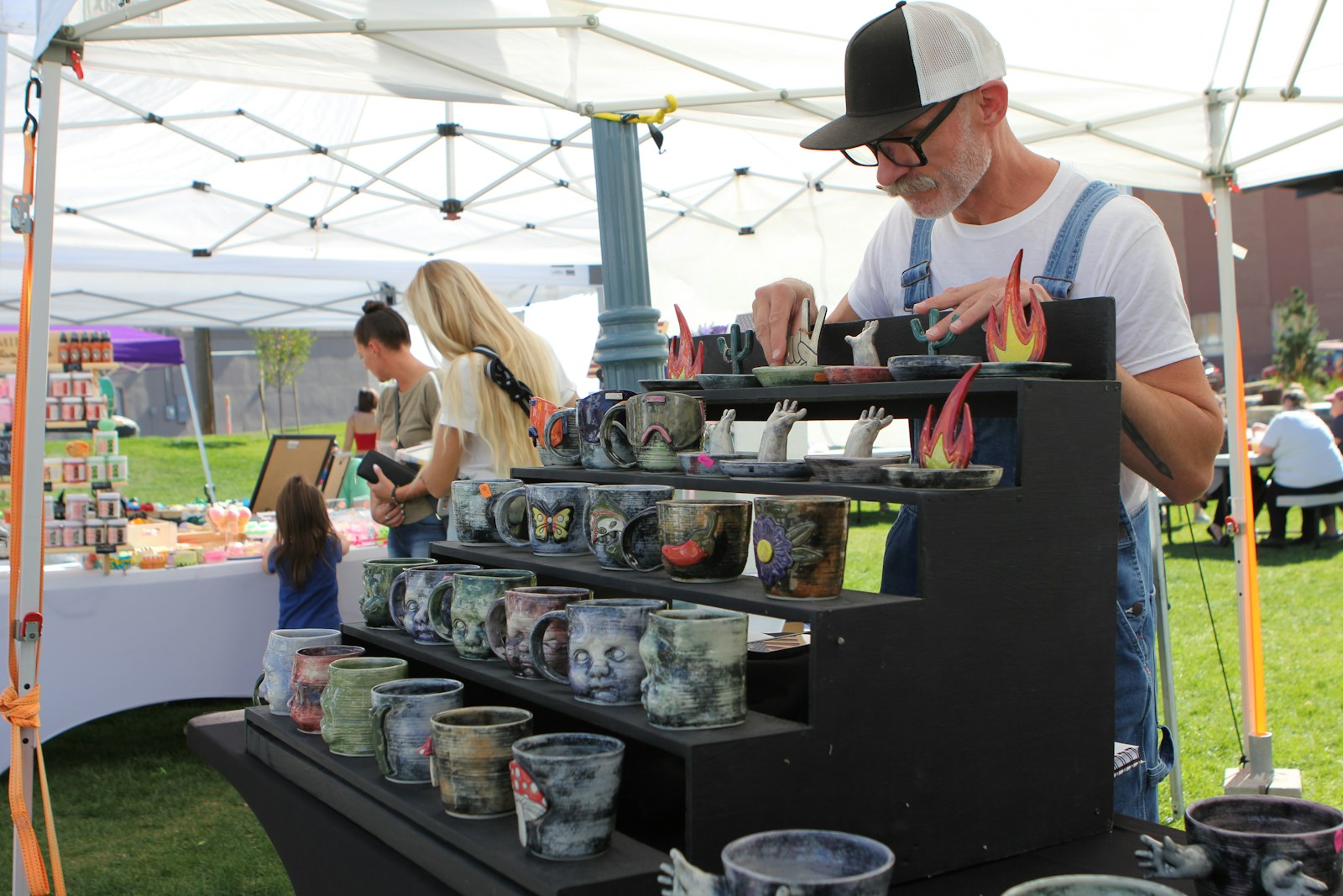 Photo by Judy Beth Morris a man standing in front of a display of vases