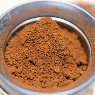 a metal bowl filled with red powder on top of a table