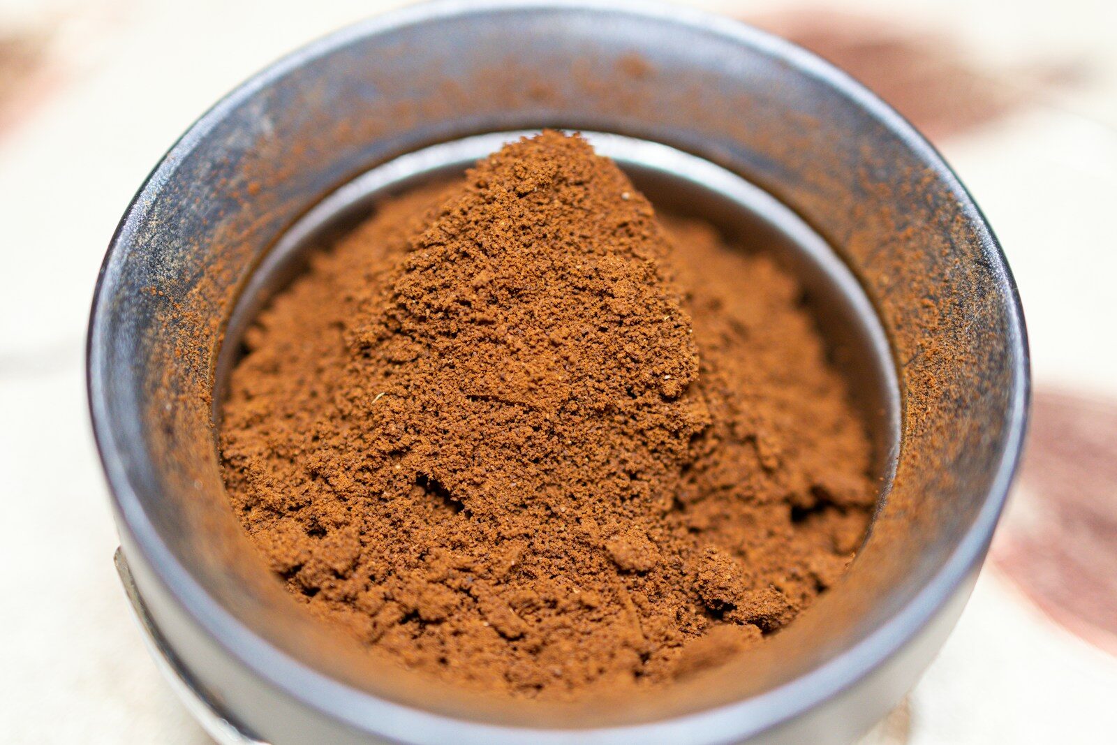 a metal bowl filled with red powder on top of a table